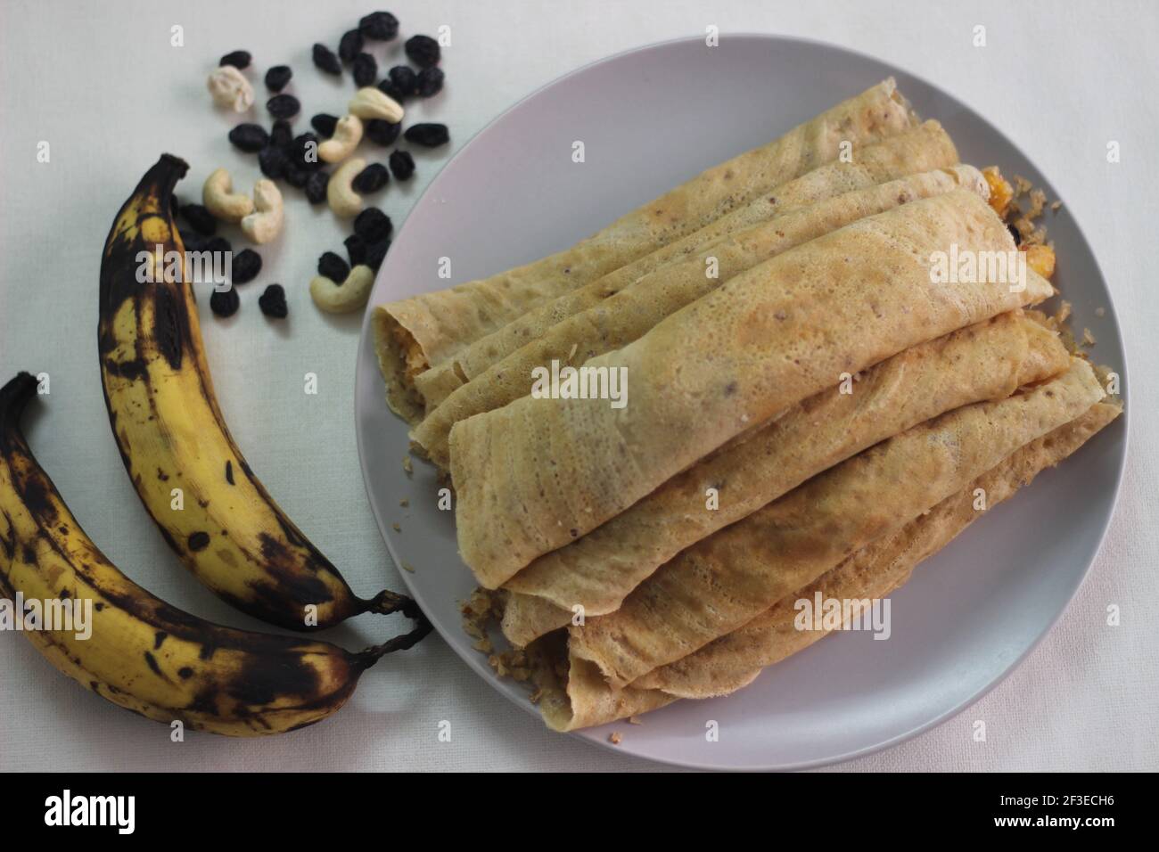 Home made Plantain Crepes or pancake with plantain coconut raisins mix in the middle. Shot on white background. Stock Photo