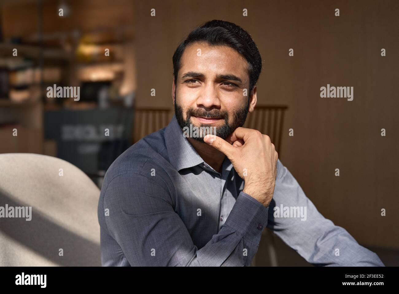 Portrait of young thoughtful indian businessman executive looking away dreaming. Stock Photo