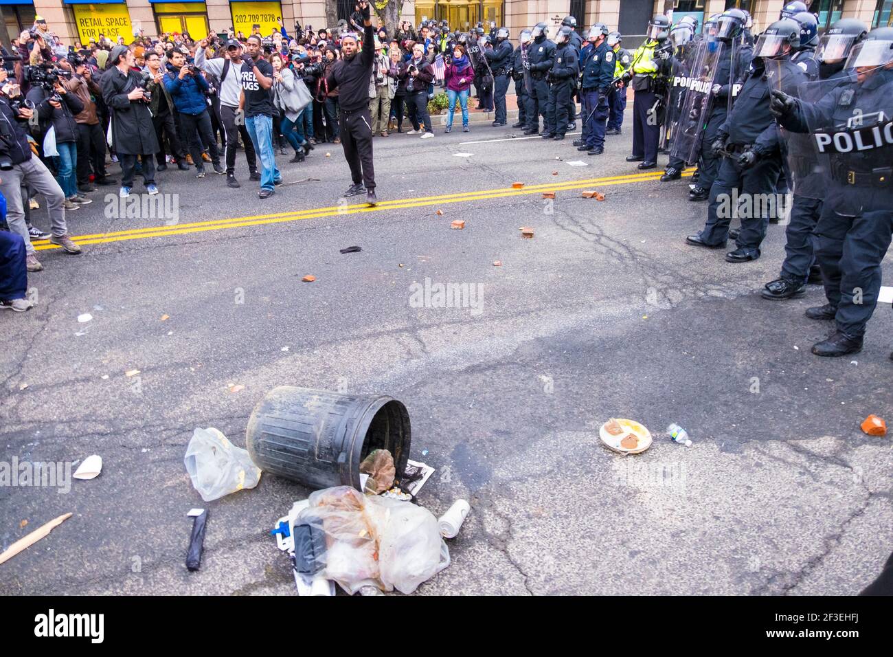 Riot police and protestors with trash on the street. At President Donald Trump's 2017 inaguration in Washington D.C. Stock Photo
