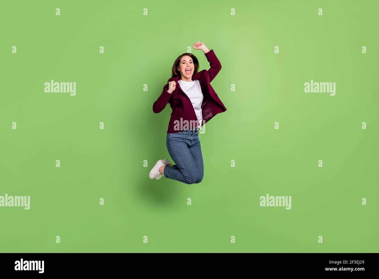 Full size profile photo of hooray brown hairdo lady jump wear cardigan jeans sneakers isolated on green background Stock Photo