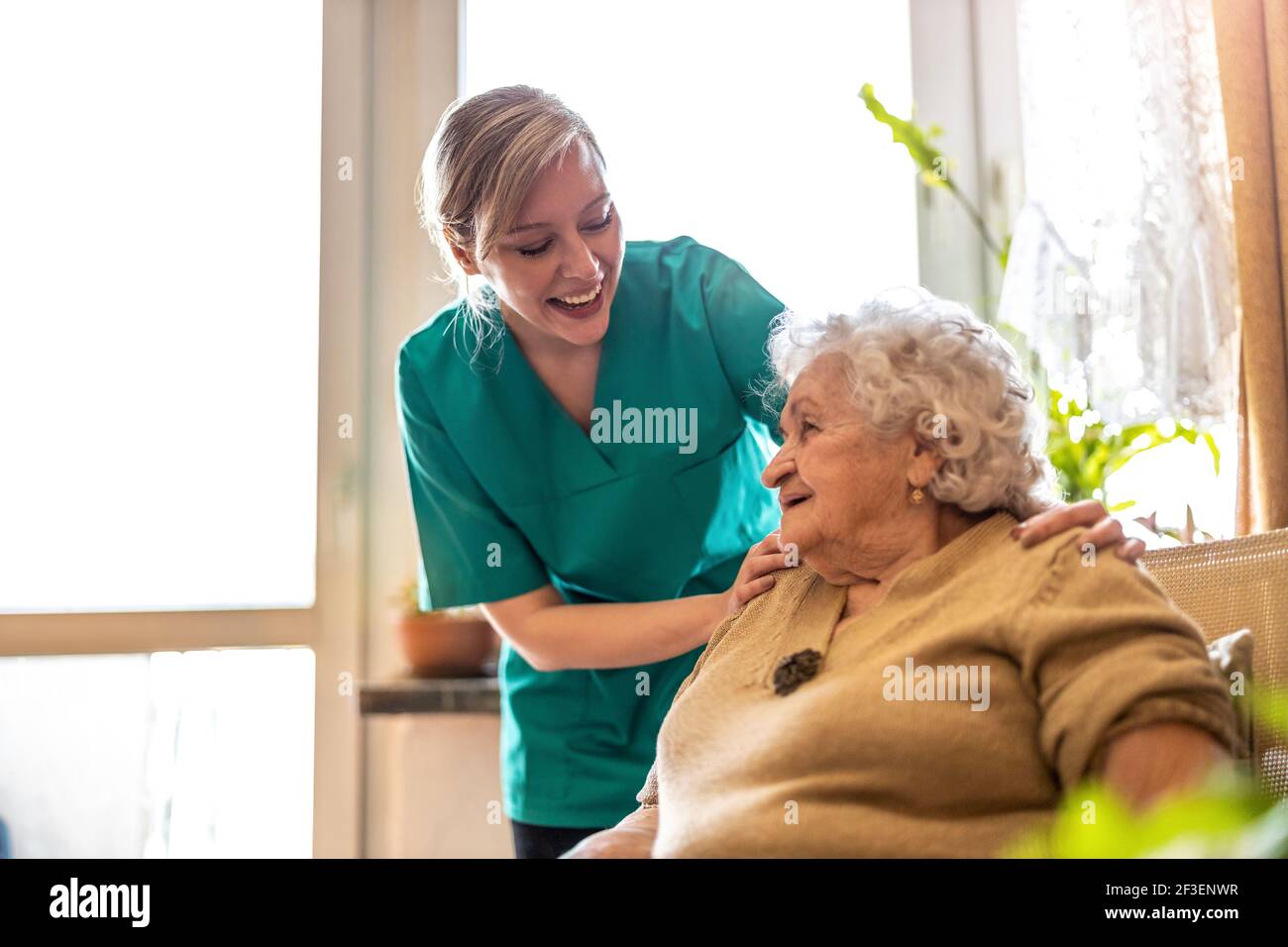 Friendly nurse supporting an elderly lady Stock Photo