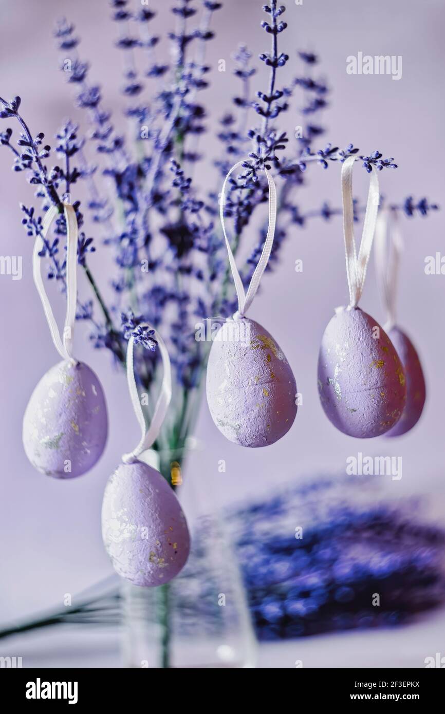 Purple Easter eggs hanging on lavender branches Stock Photo