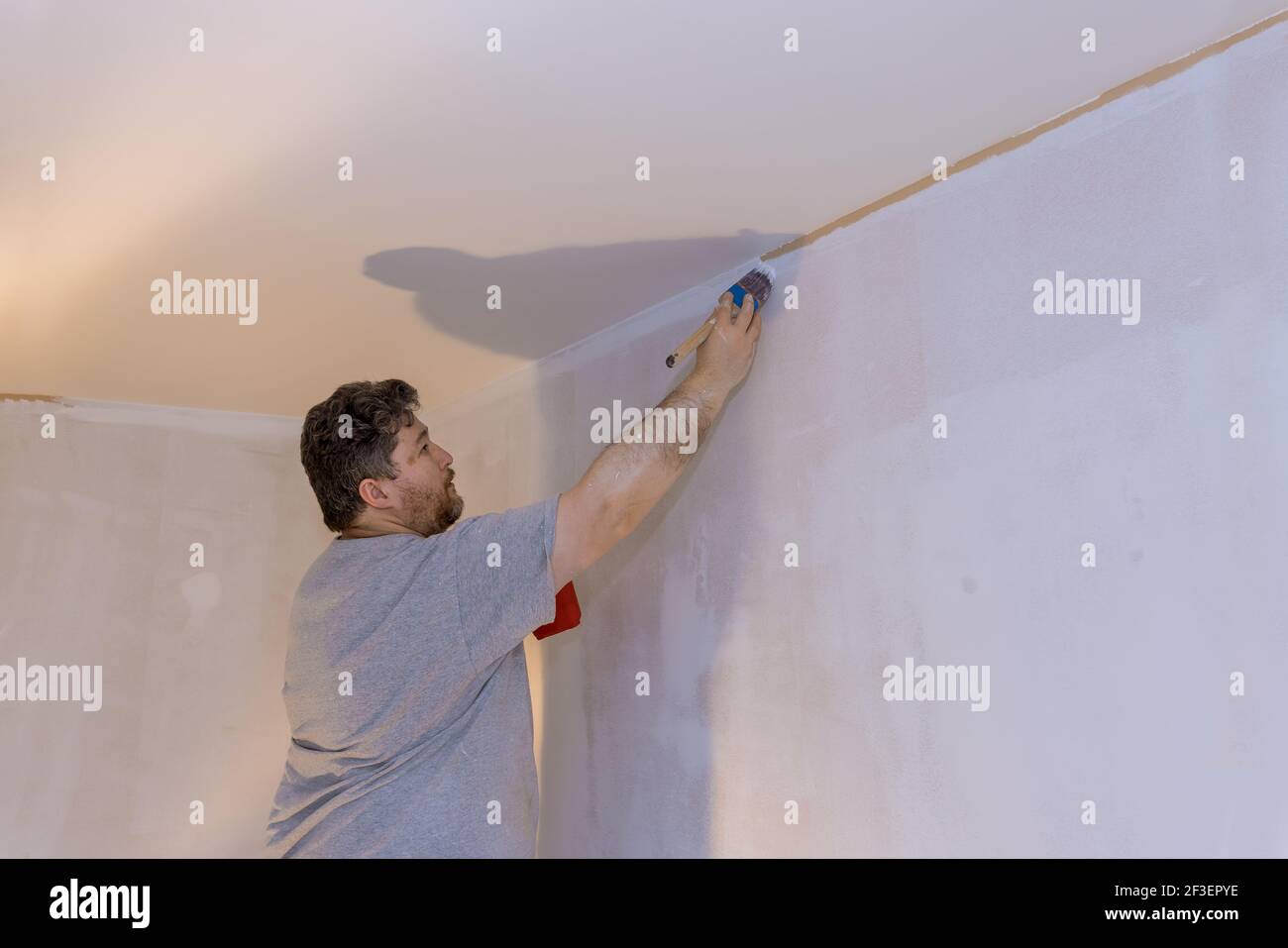 Professional painter using a brush to paint on wall Stock Photo Alamy