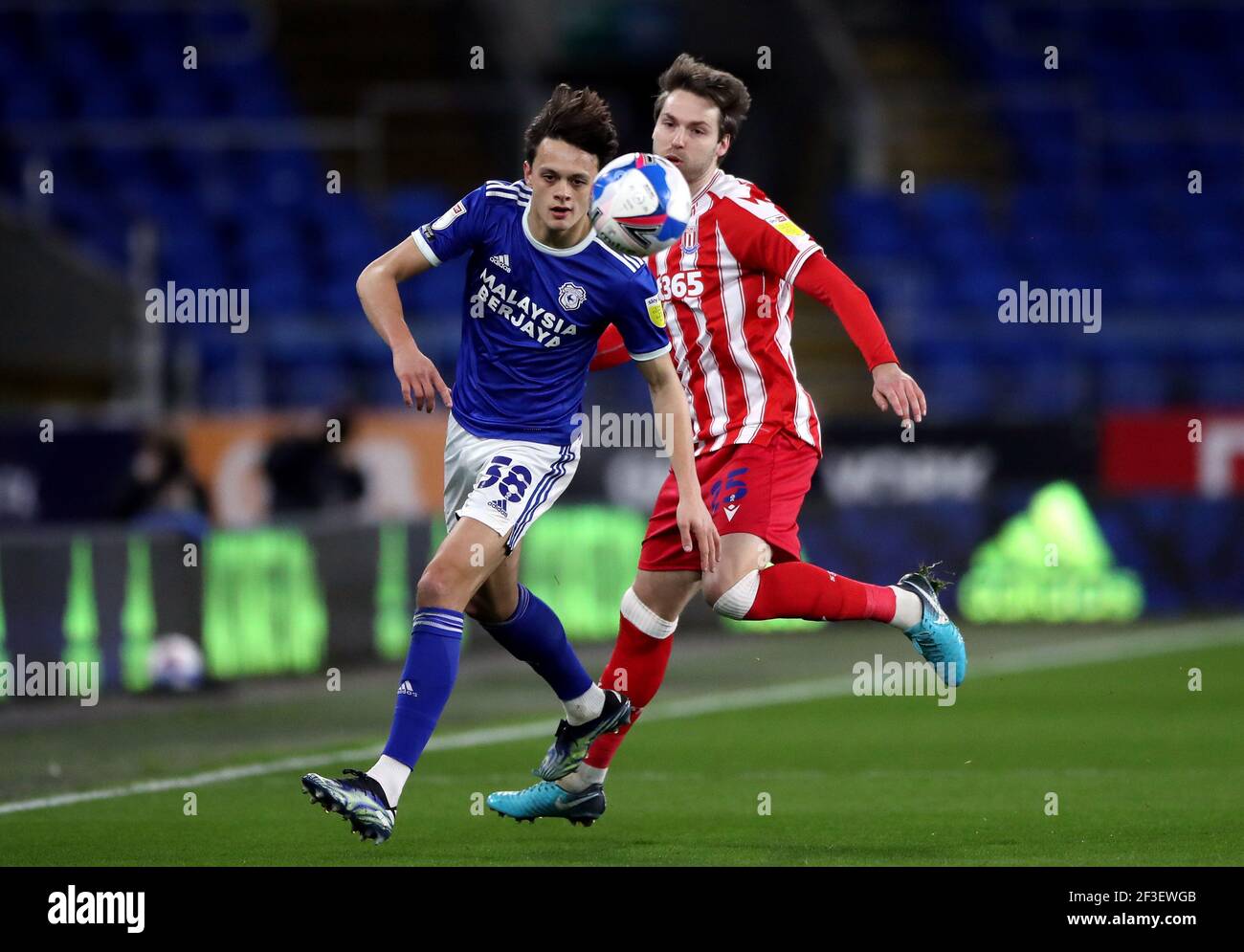 Cardiff City's Perry Ng (left) and Stoke City's Nick Powell battle for the ball during the Sky Bet Championship match at Cardiff City Stadium, Cardiff. Picture date: Tuesday March 16, 2021. Stock Photo
