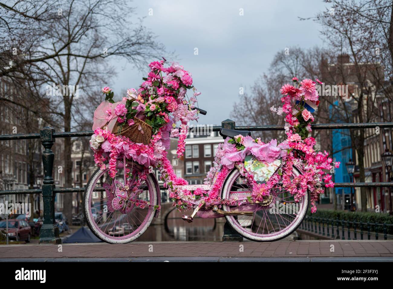 Old vintage woman bicycle decorated with pink flowers on small bridge in  old part of Amsterdam Stock Photo - Alamy