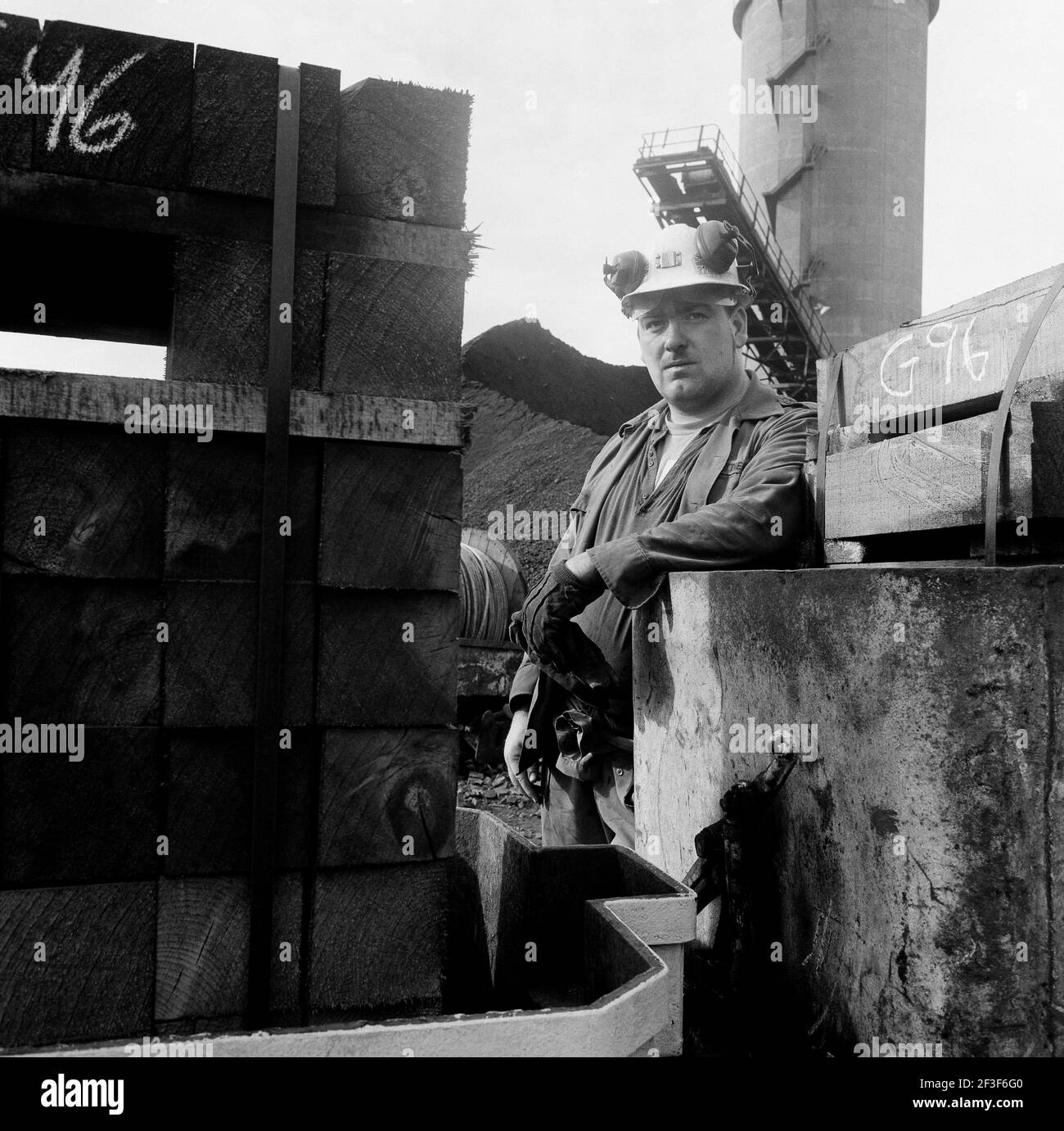 Worker taking a break between wooden stacks on the surface at Monkwearmouth Colliery Stock Photo