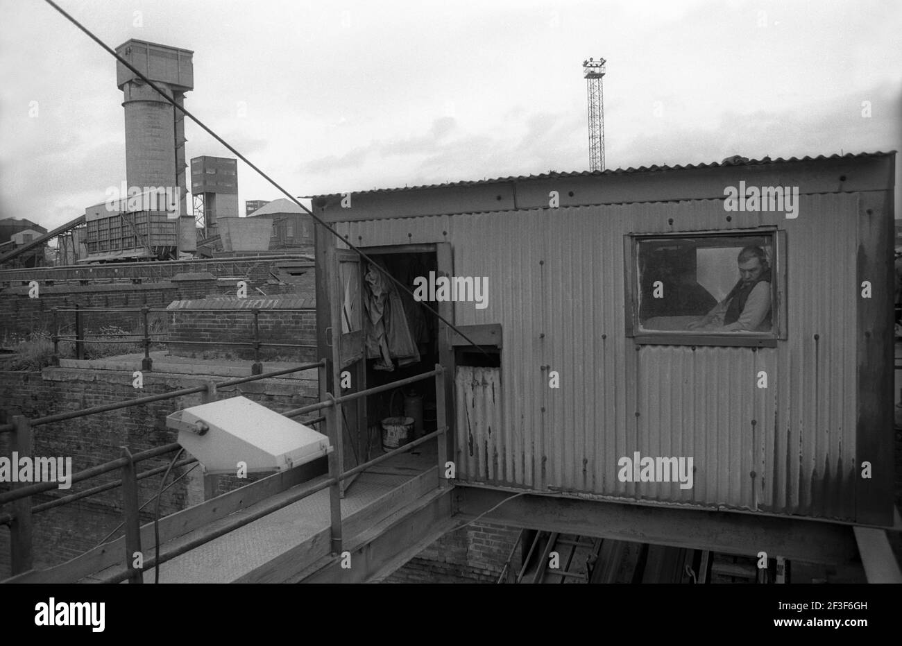 Worker looking out of a workshop window on the surface at Monkwearmouth Colliery Stock Photo