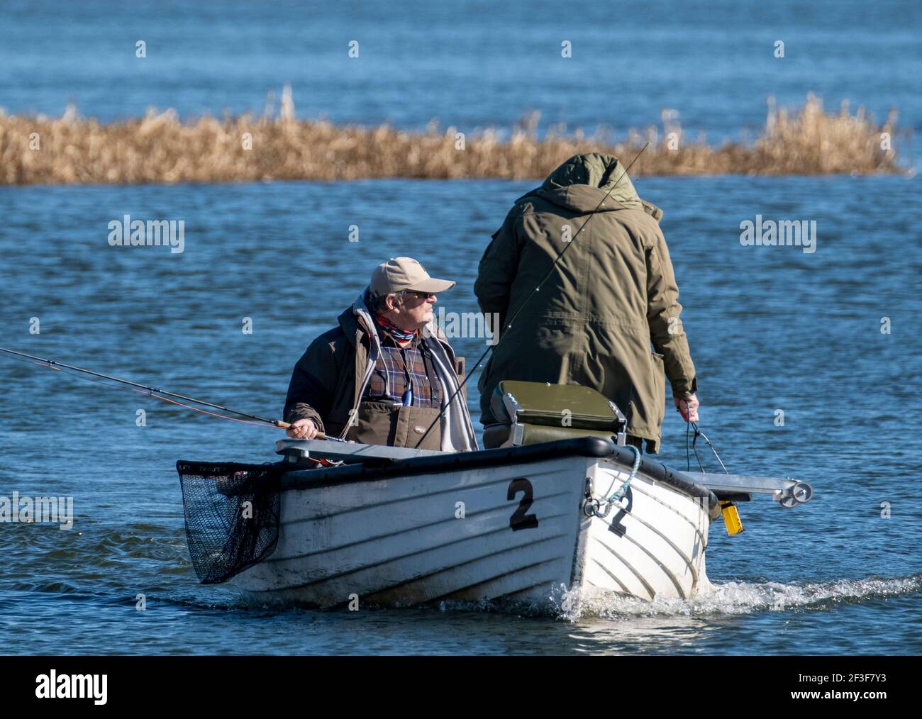 Men fly fishing from boats on Linlithgow Loch with Linlithgow