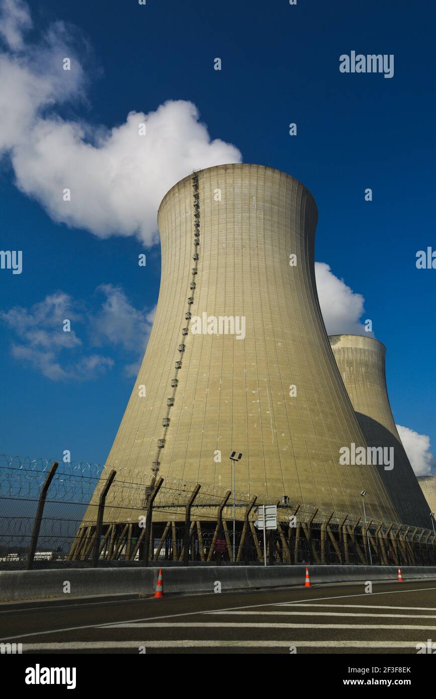 Vertical view of cooling towers with water steam on a blue sky, nuclear