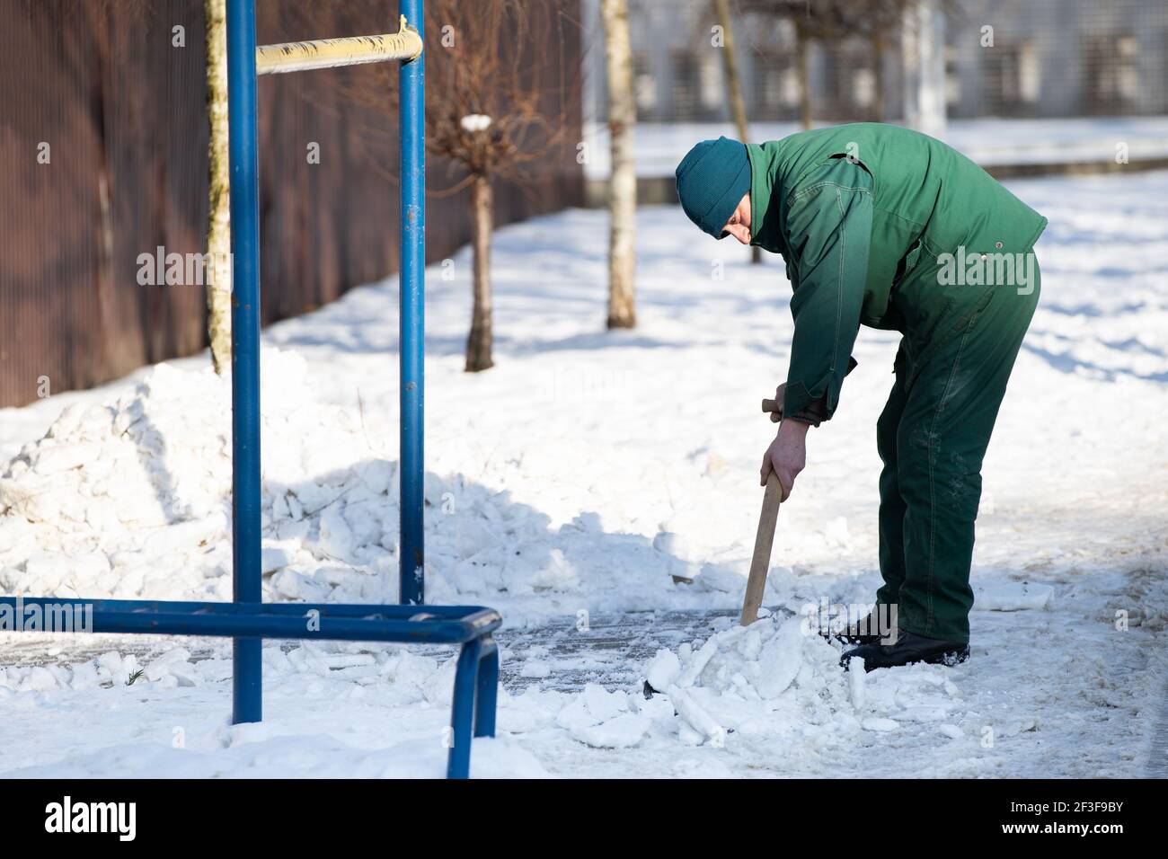 A manual worker scoops wet snow and ice on a shovel Stock Photo - Alamy