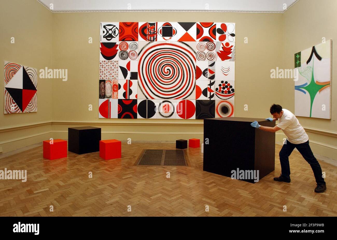 ART HANDLERS ADJUSTING 'INSTALLATION,CONTRAST IN RED ,BLACK AND WHITE BY TERRY FROST.,PART OF