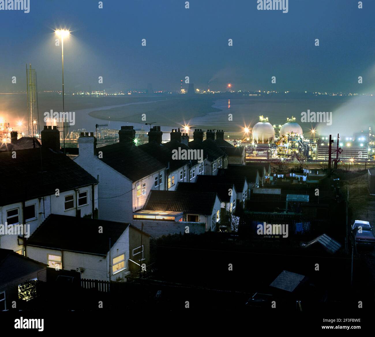 Houses close to a hazardous chemical plant: the Ineos Chlor Chemical complex, Runcorn, Cheshire. In the background is the Mersey estuary. Stock Photo