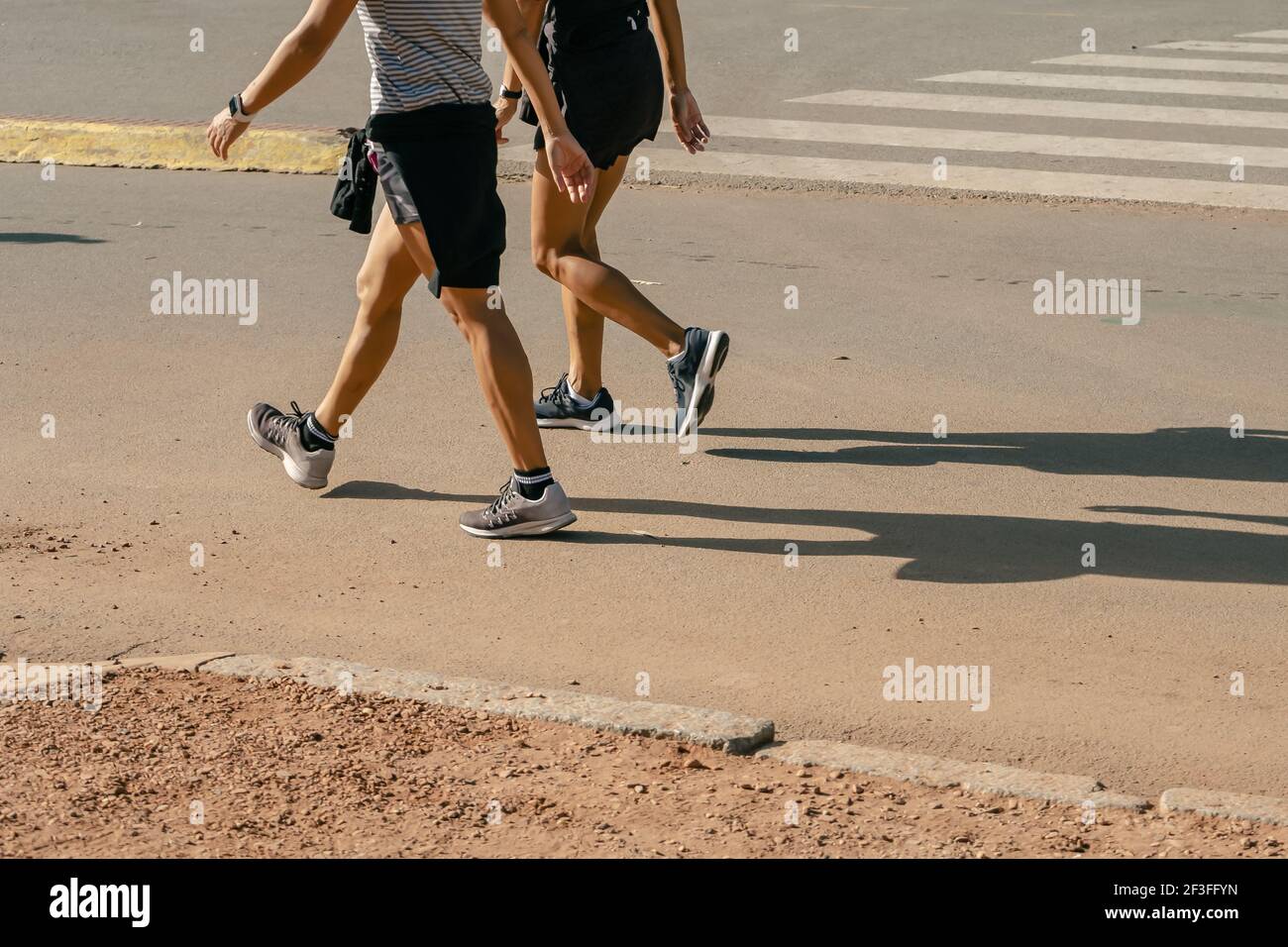 Runner feet running on road closeup on shoe. Peoples fitness sunrise jog workout welness concept. Stock Photo