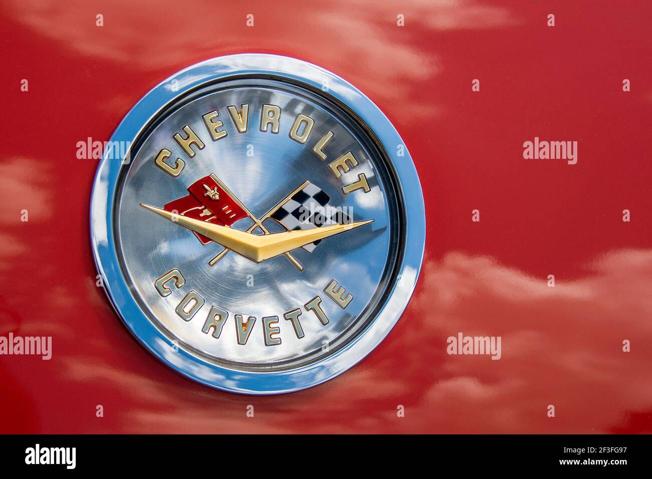 Chevrolet Corvette Hood Emblem with cloud reflections on bright red vehicle body. Stock Photo