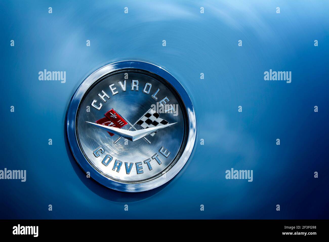 Chevrolet Corvette crossed flag emblem on blue vehicle with cloud reflection. Stock Photo
