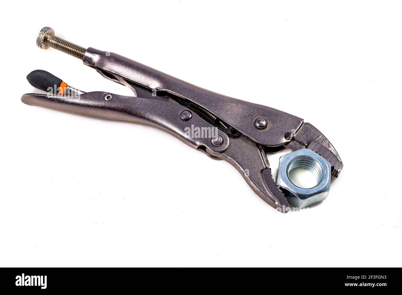 Adjustable wrench with a tightened nut. Accessories for mechanics carrying out repairs in the household. Light background. Stock Photo