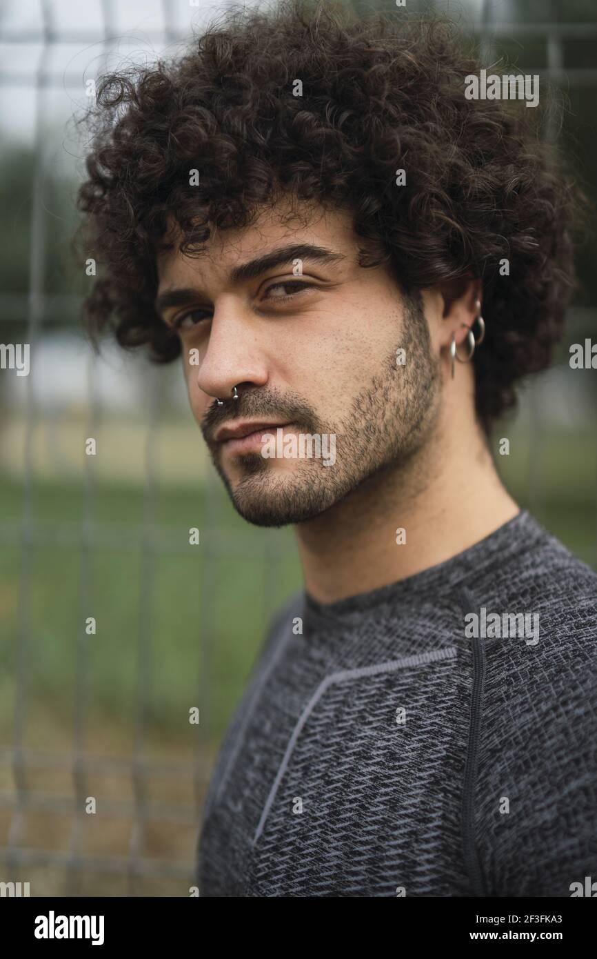 A portrait of a young Spanish male with dark curly hair and piercing Stock  Photo - Alamy