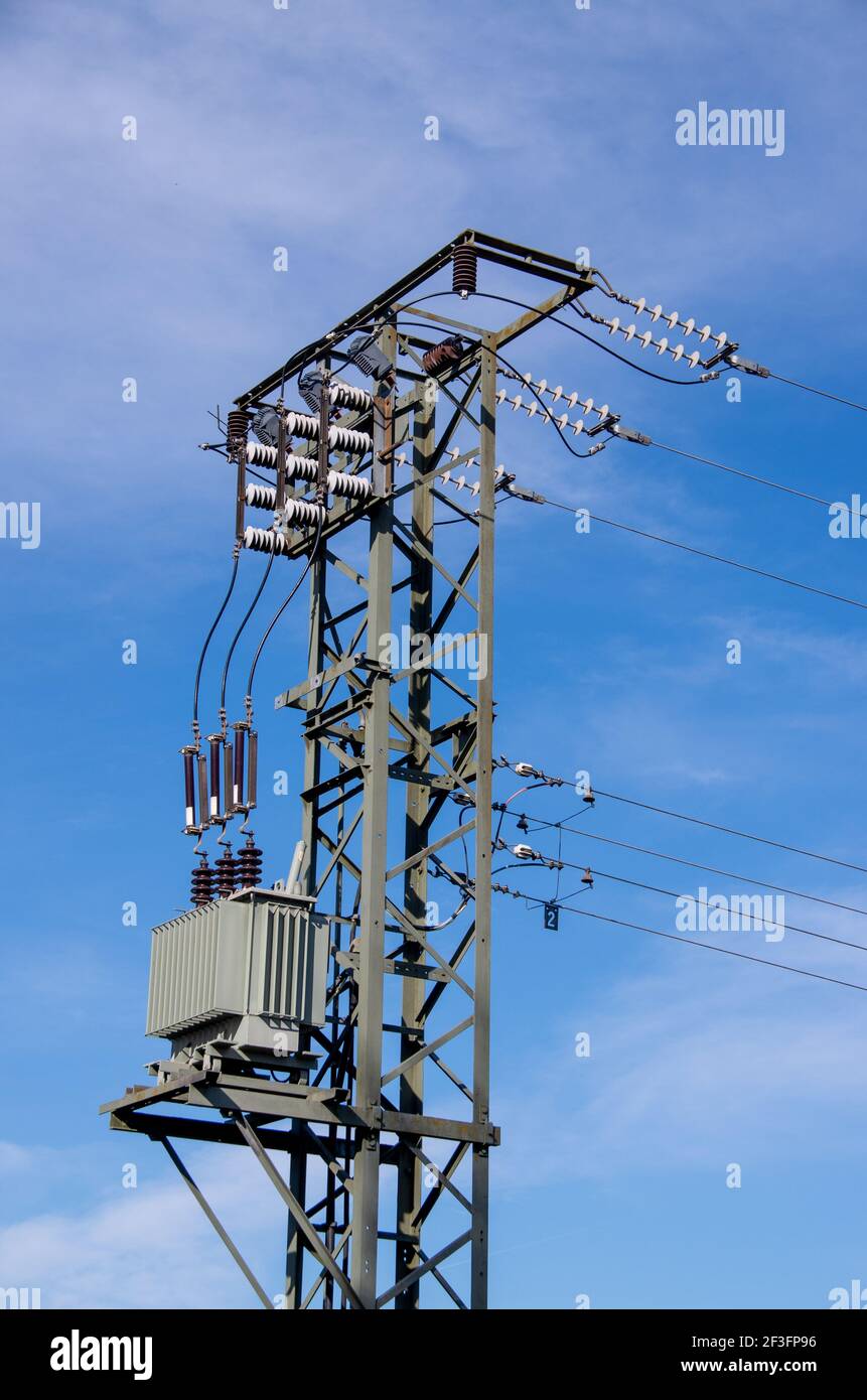 Electricity mast with transformers in front of blue blue sky Stock Photo