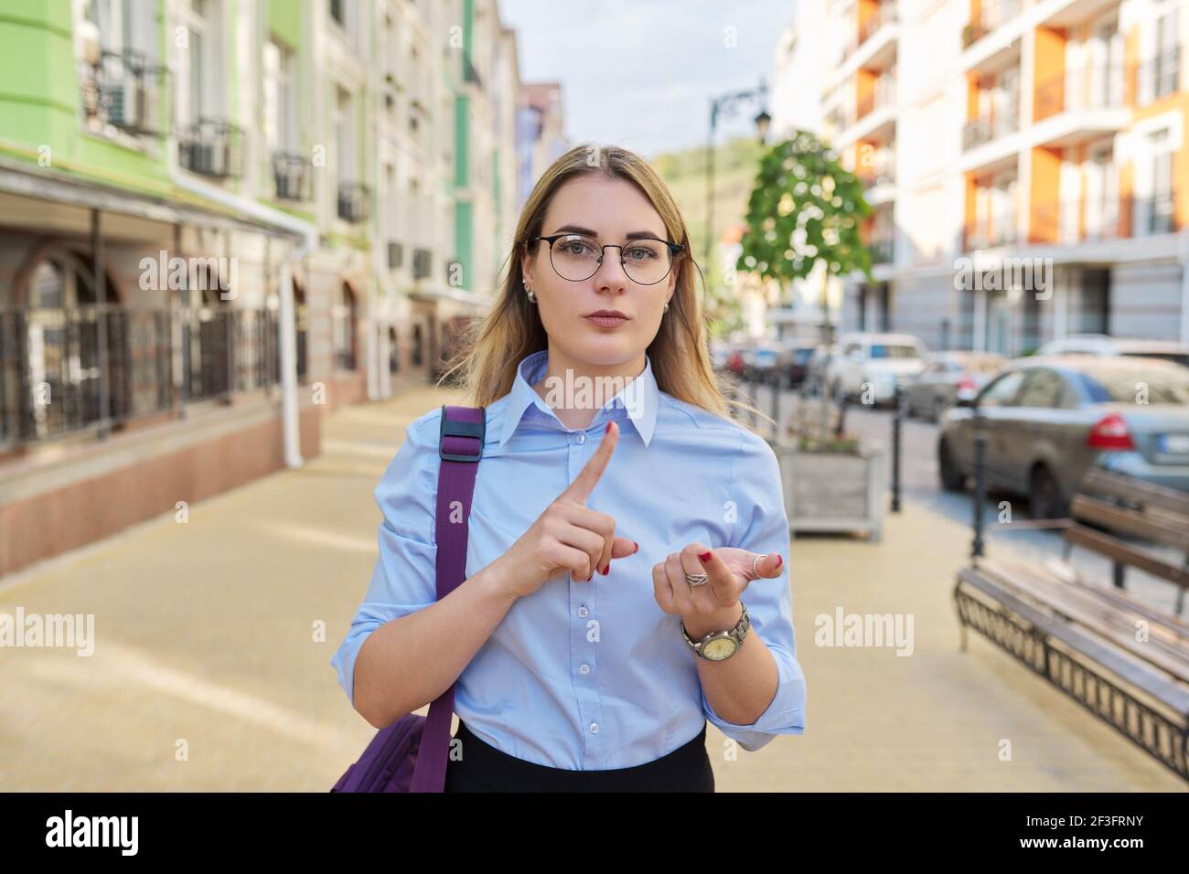 Outdoor portrait of talking young business woman in city female looks at web camera Stock Photo Alamy