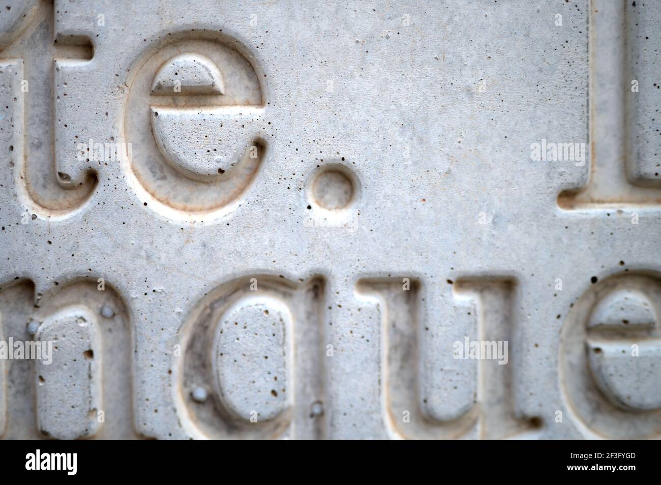 detail of a set of letters and words engraved on a gray concrete wall Stock Photo Alamy