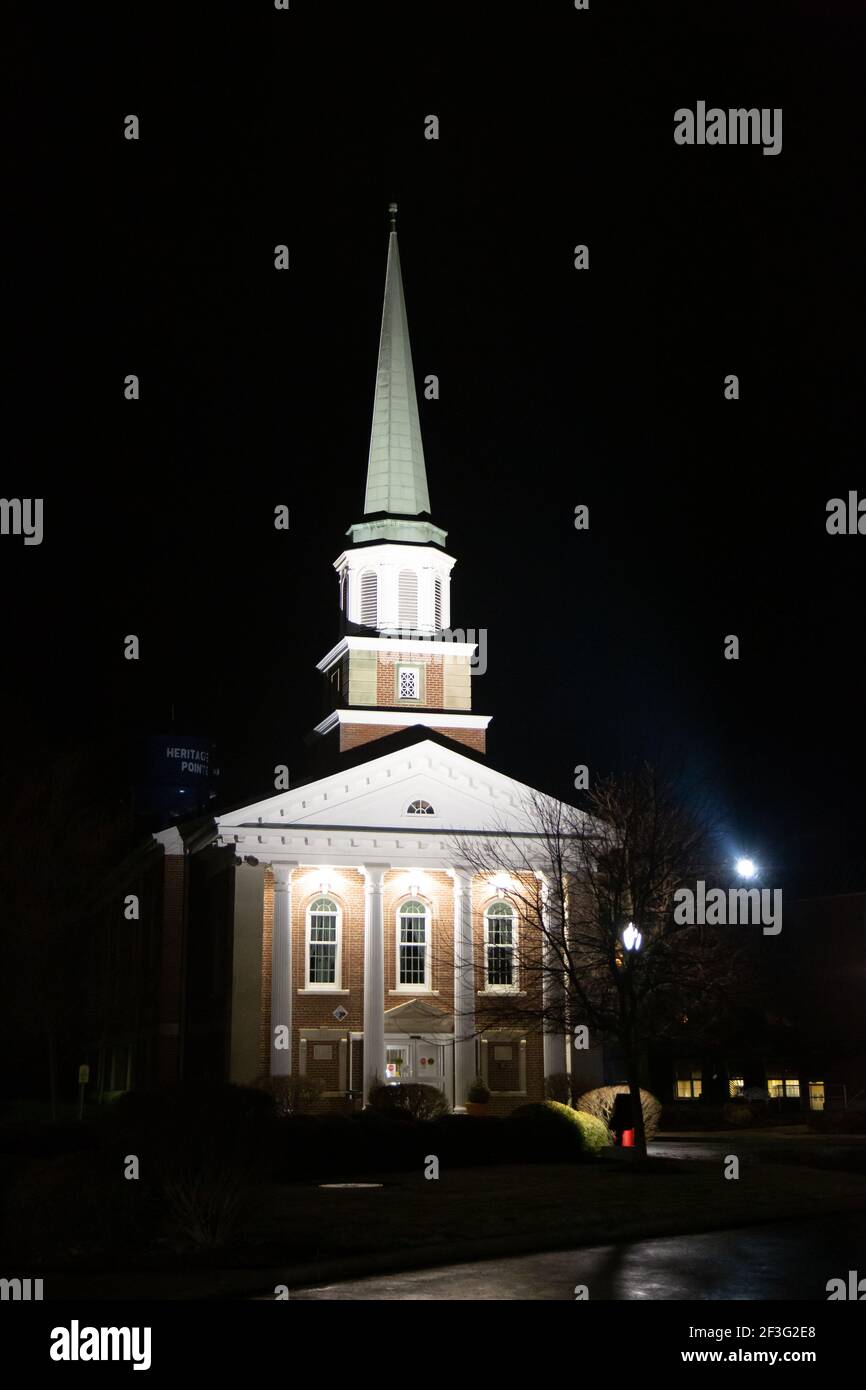 The illuminated Heritage Pointe chapel and its towering steeple in
