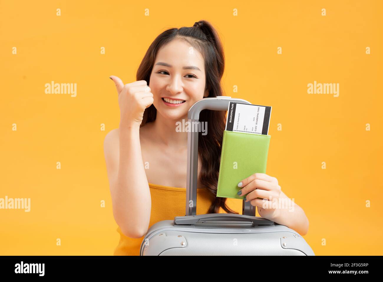 Asian woman long hair wear Straw hat in hand holding passport book and travel bag Stock Photo