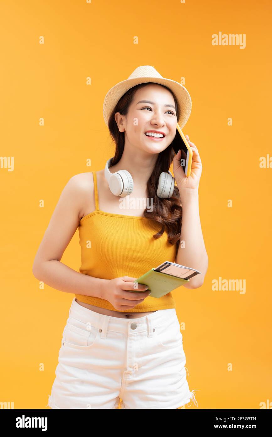 Asian woman long hair wear Straw hat in hand holding passport book and mobile Stock Photo