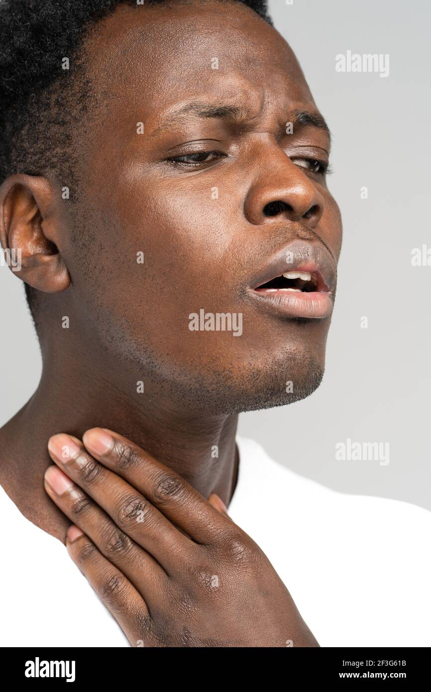 Black man touches fingers of sore throat, thyroid gland. Painful