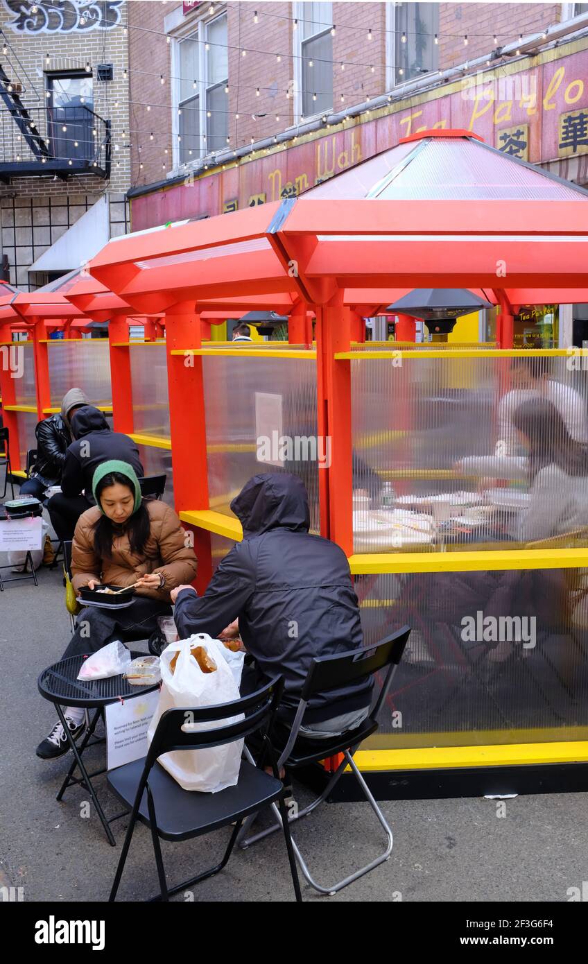 Customers eating at outdoor seatings and covered outdoor dining huts of