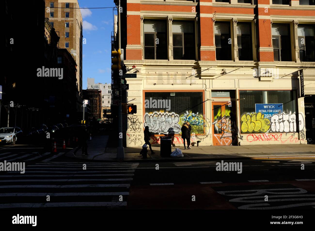 Graffitis covered empty store window with for rent sign along Broadway street in Lower Manhattan during Covid-19 pandemic.New York City.USA Stock Photo