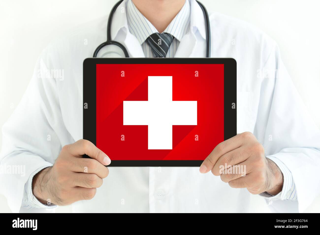 First aid sign on tablet pc screen held by doctor Stock Photo