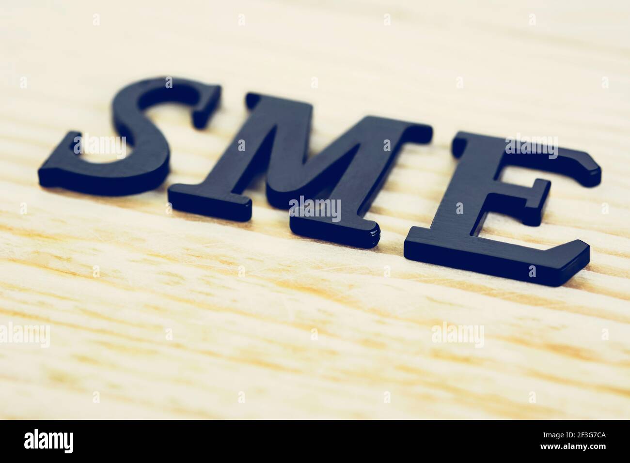 SME (or Small and Medium Enterprises) sign on wood background Stock Photo