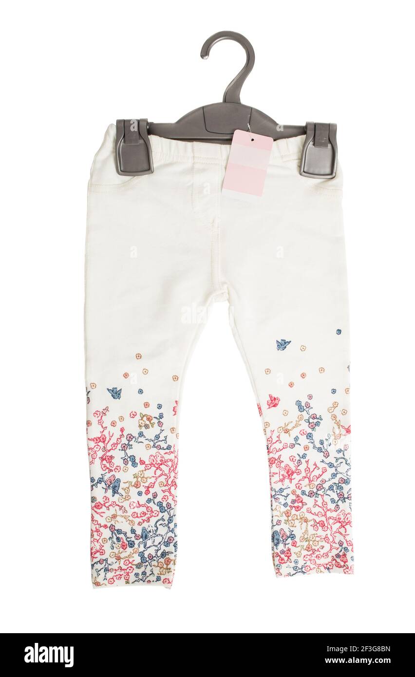 White denim jeans with floral pattern on black plastic hanger. Isolated on a white background. Stock Photo
