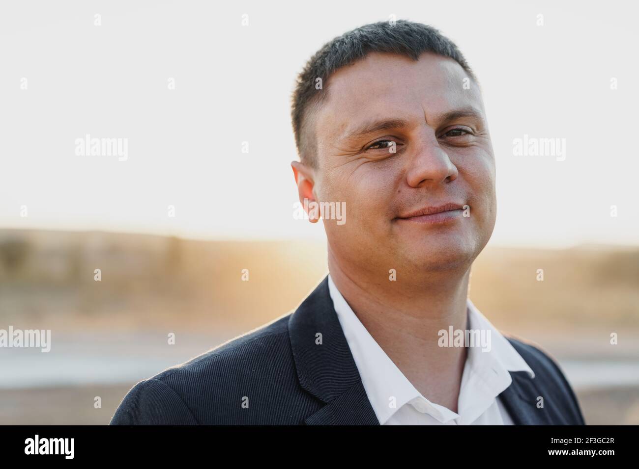 Portrait of a young smiling man in a suit Stock Photo - Alamy
