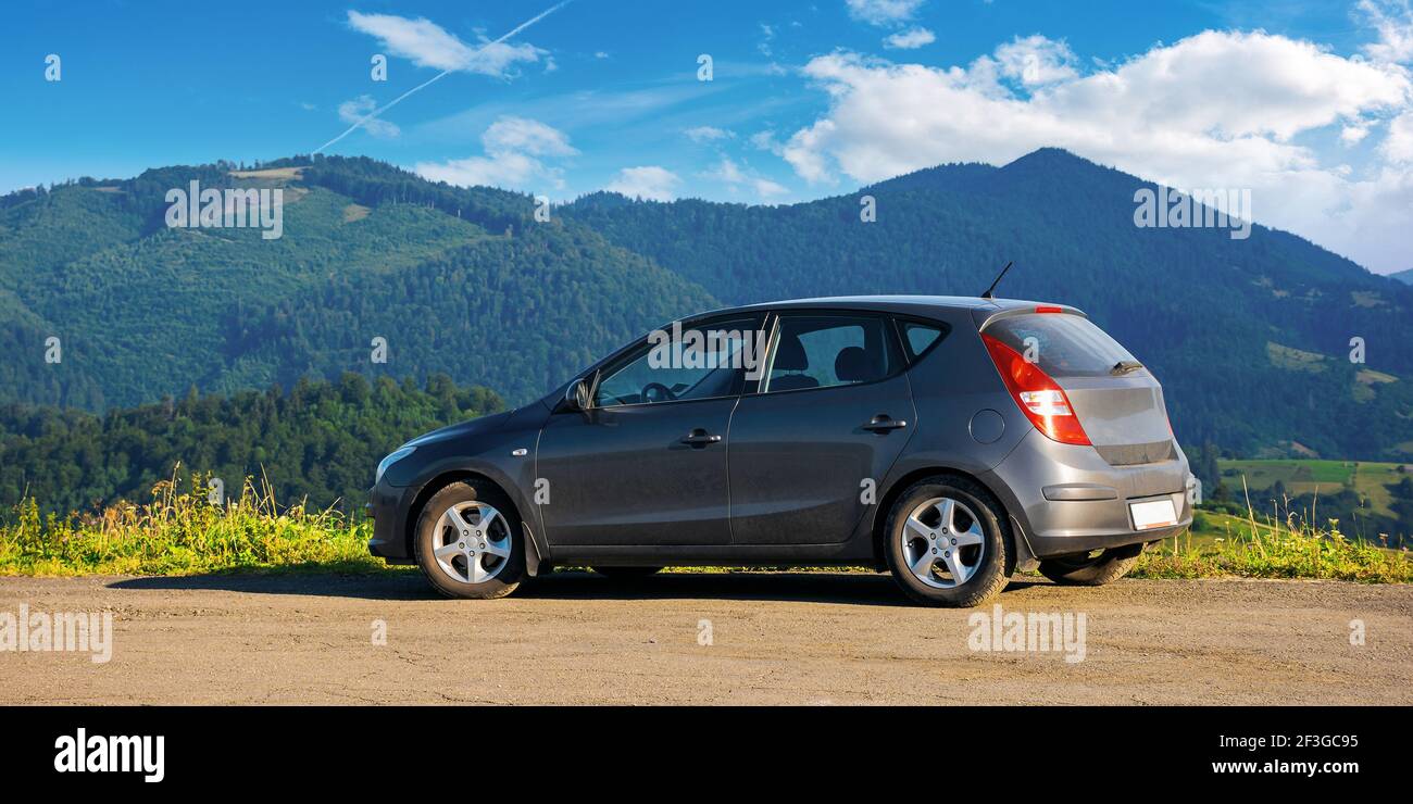 mizhhirya, ukraine - AUG 08, 2020: car on the concrete parking on top of the mountain in morning light. travel countryside concept. beautiful nature s Stock Photo