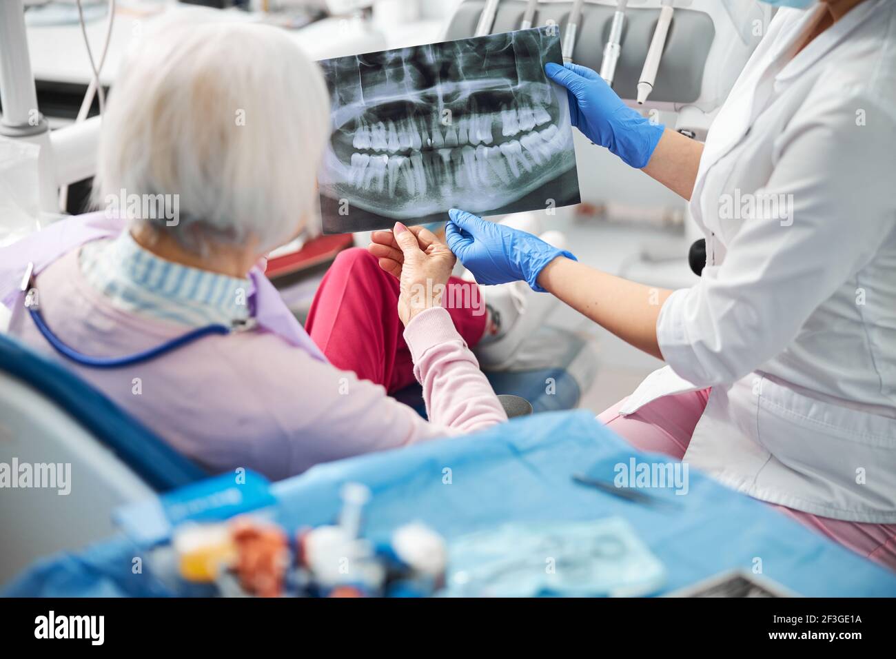 Medical specialist showing her client x-ray with teeth image Stock Photo