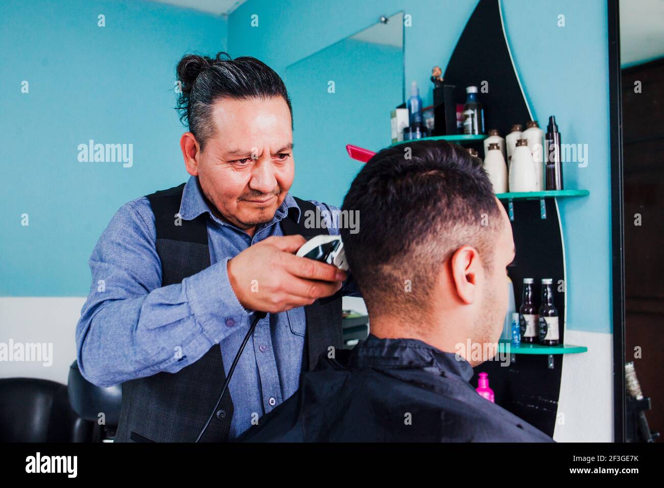 latin man stylist cutting hair to a client in a barber shop in Mexico Stock Photo Alamy