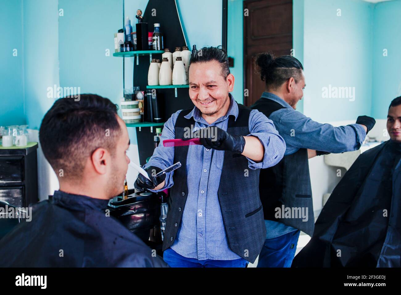 latin man stylist cutting hair to a client in a barber shop in Mexico Stock Photo Alamy