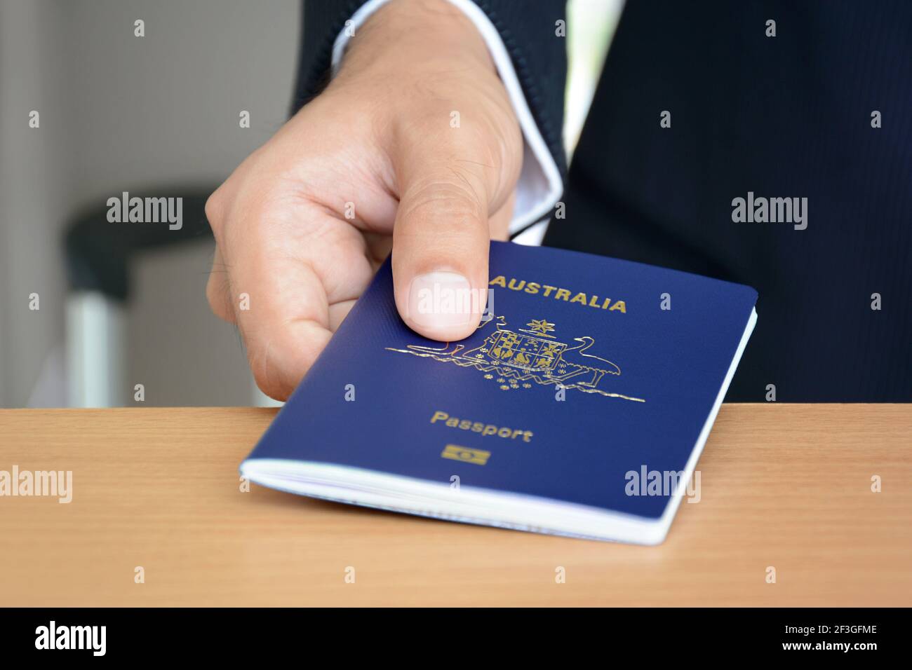 Hands giving passport (of Australia) Stock Photo