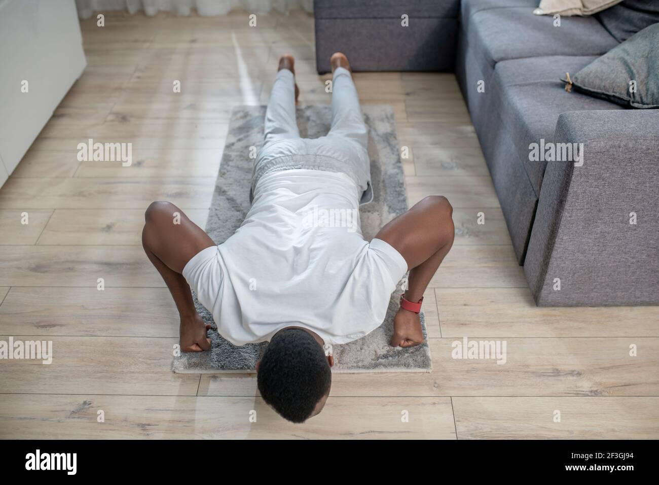 African american guy in white clothes doing morning exercises Stock ...