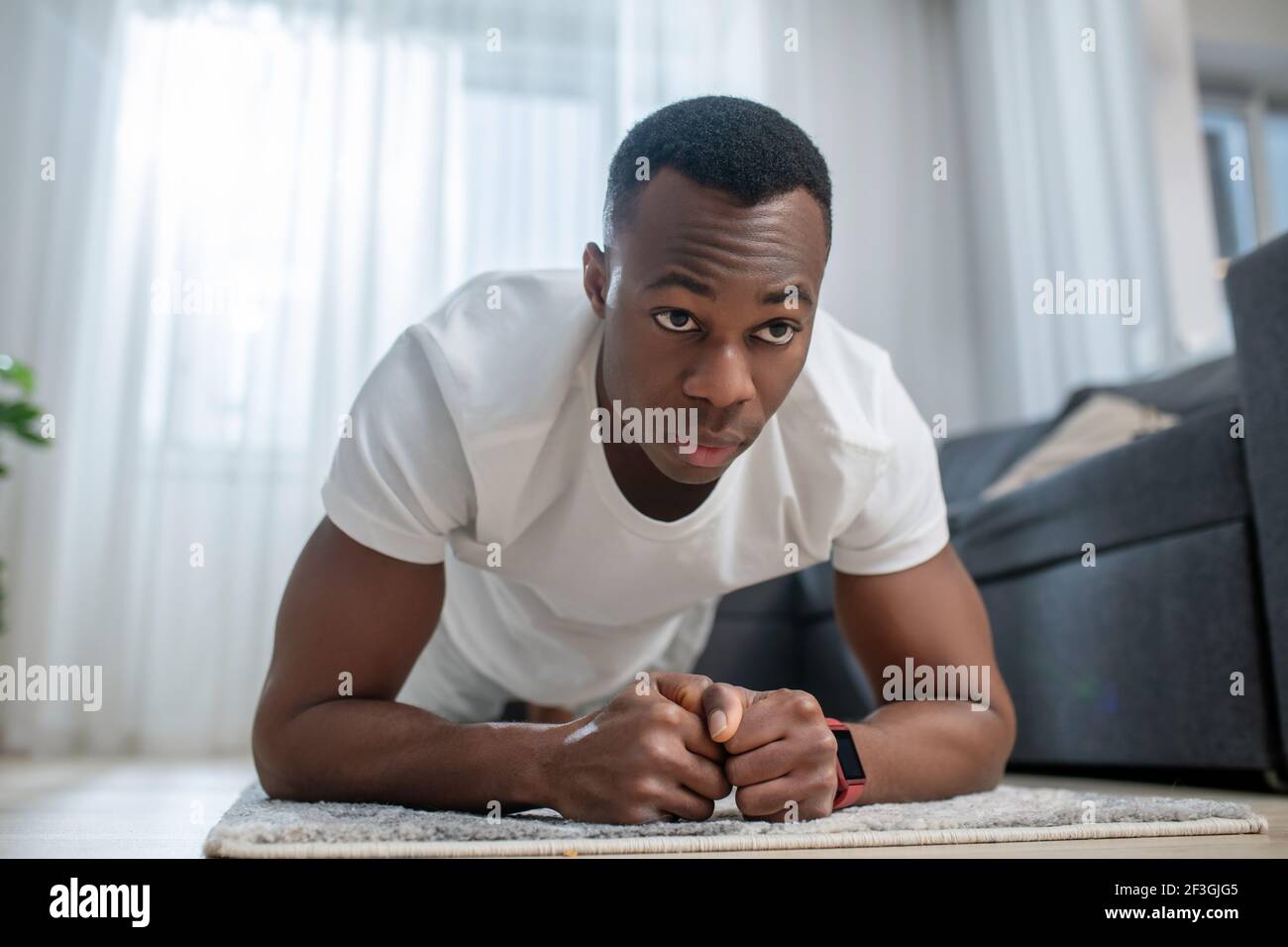 African american guy in white clothes doing morning exercises Stock ...
