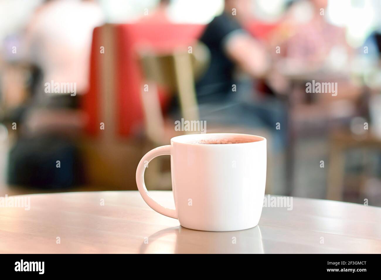 Hot drink on the table with people sitting in cafe as blur background Stock Photo