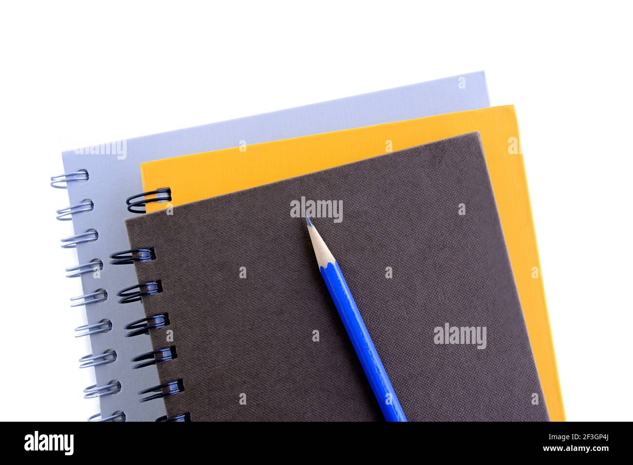 Stack of notebooks or copybooks with pencil on top - white background Stock Photo