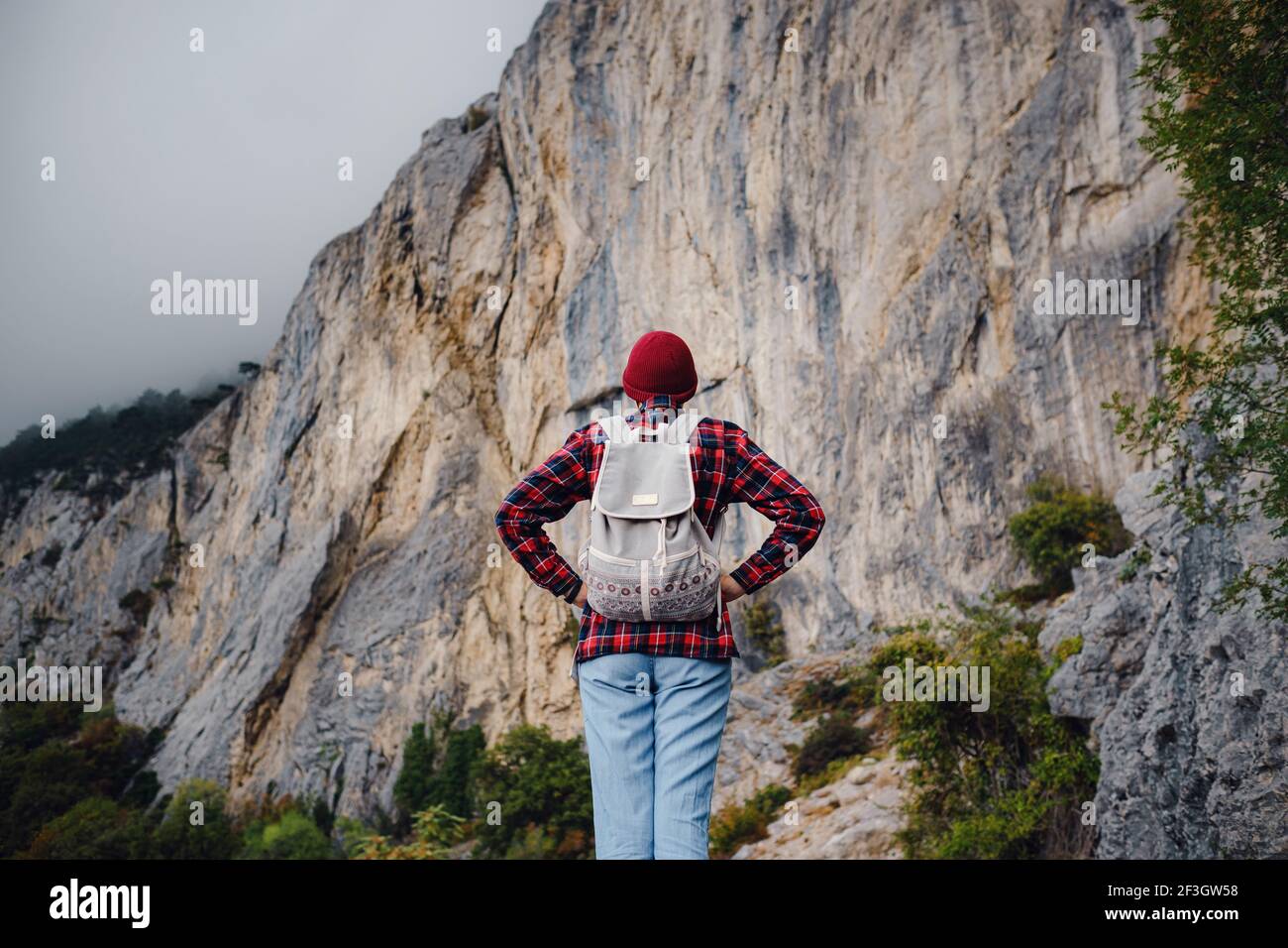 Image showcasing Asian hipster woman walking alone on a mountain highway on an autumn ...