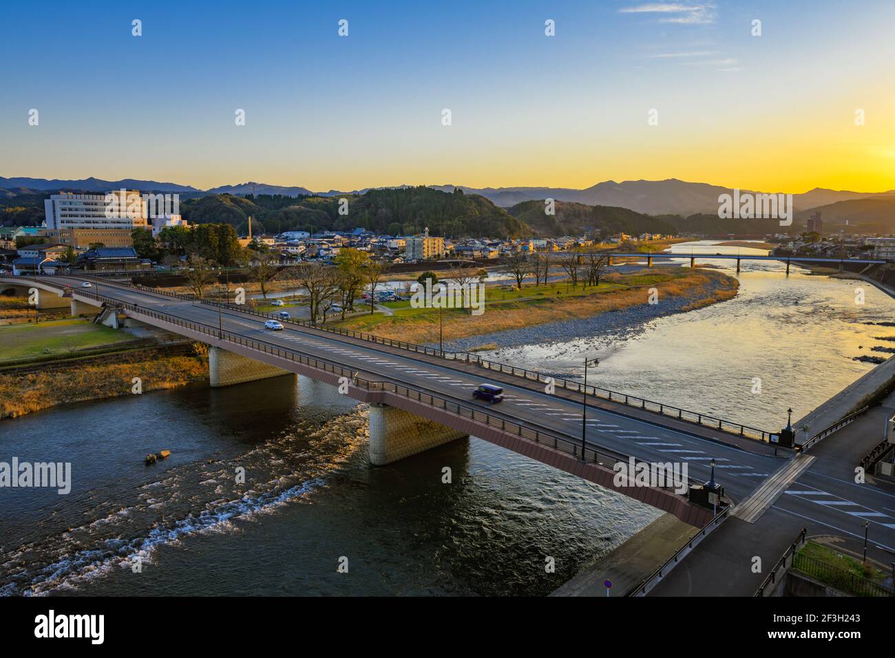 Kumamoto, Japan, 17 March 2020 - Sunset of quiet town in Kumamoto. Cars travelling across bridge over Kuma River. Stock Photo