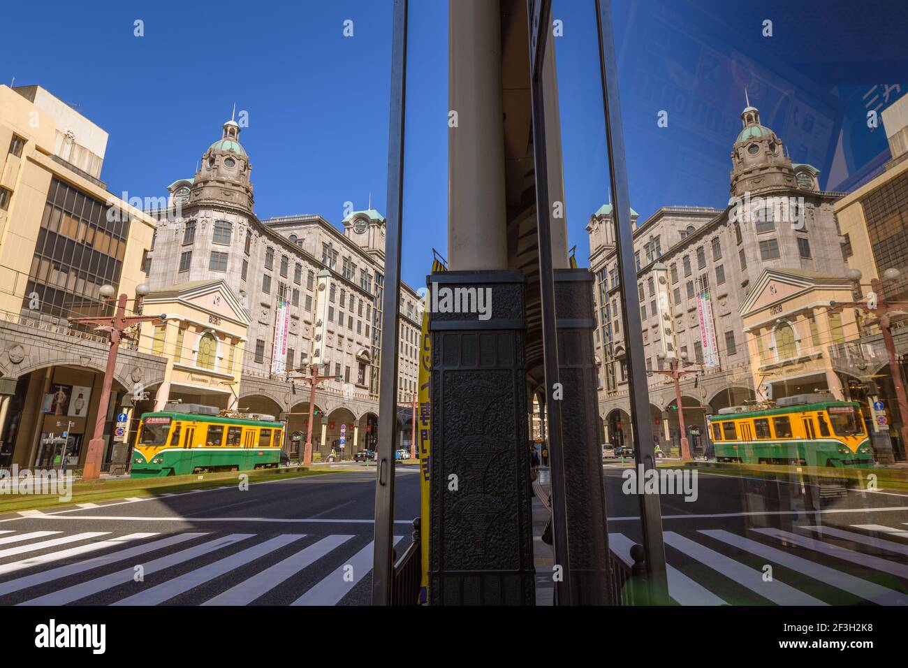 Kagoshima, Japan, 20 March 2020 - Tram with historical Yamakata-ya building in shopping district in Tenmonkan, Kagoshima, Japan. Stock Photo