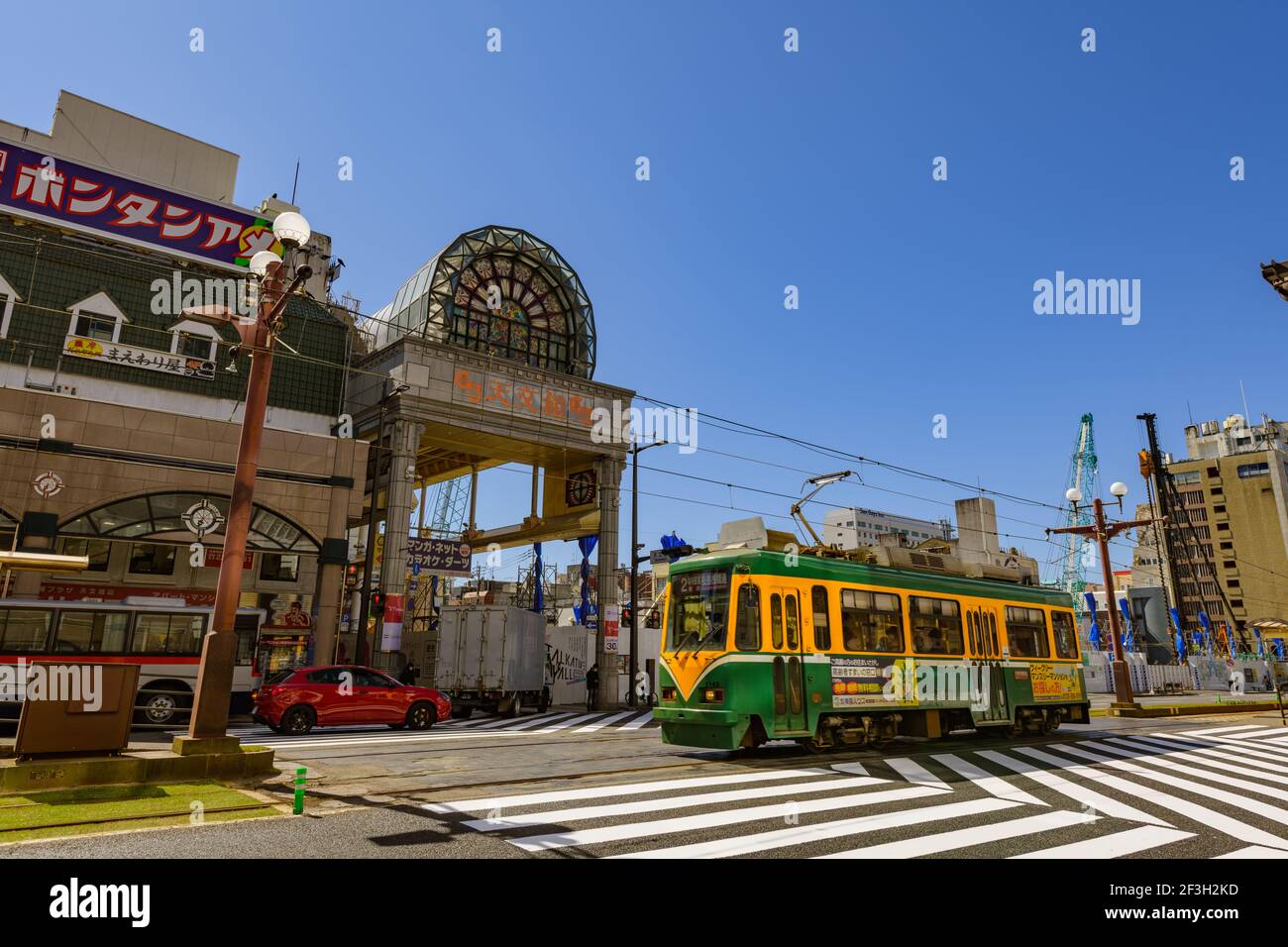 Traditional tram in operation on street in city, Kagoshima, Japan Stock Photo