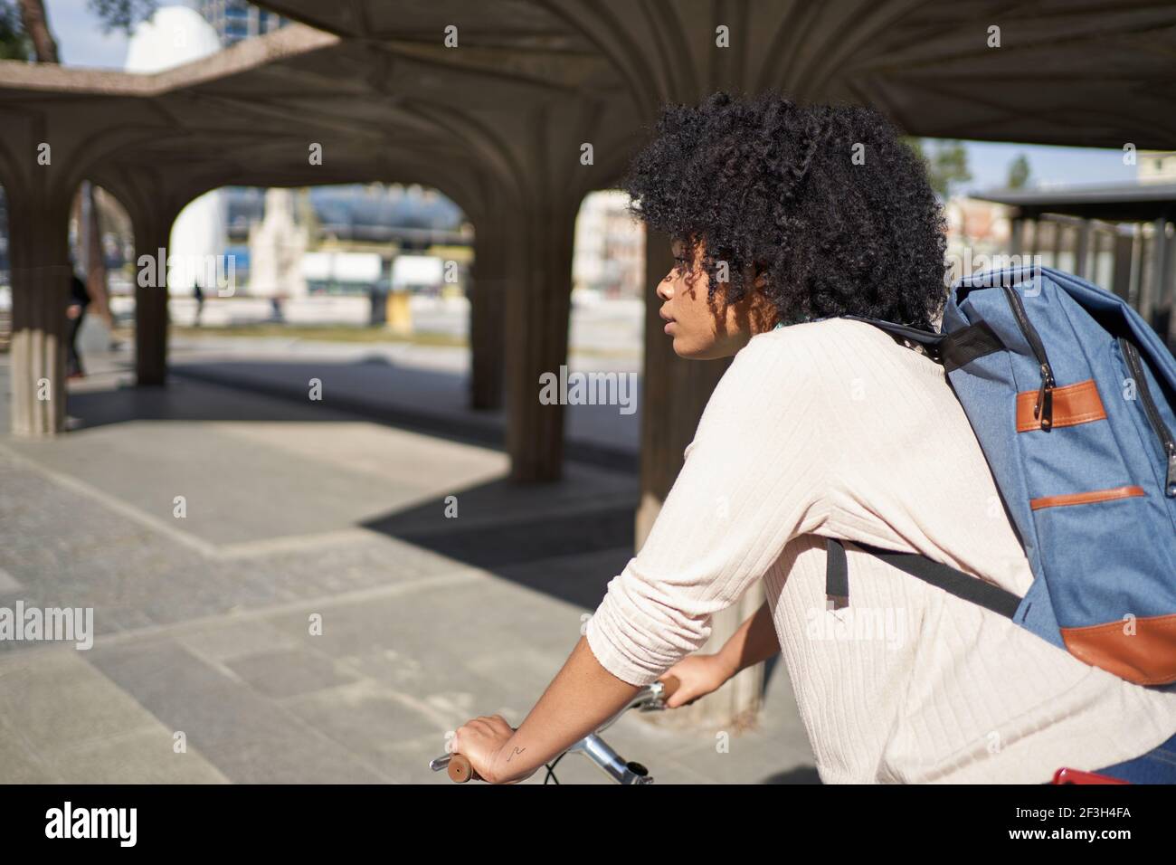 Latina woman riding a bicycle in the city. African American woman using ...