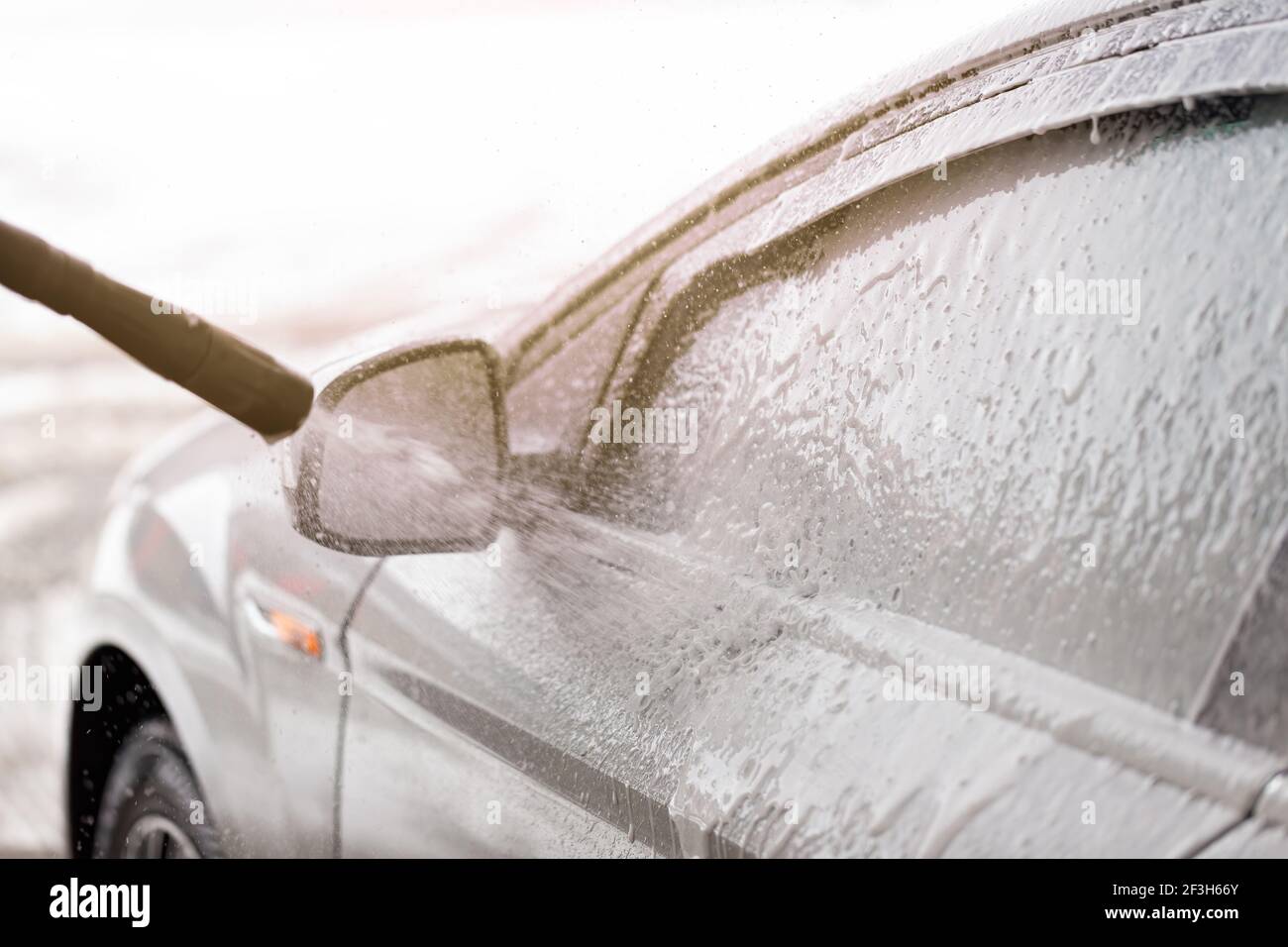 Cleaning car with high pressure hose in exterior washbasin Stock Photo