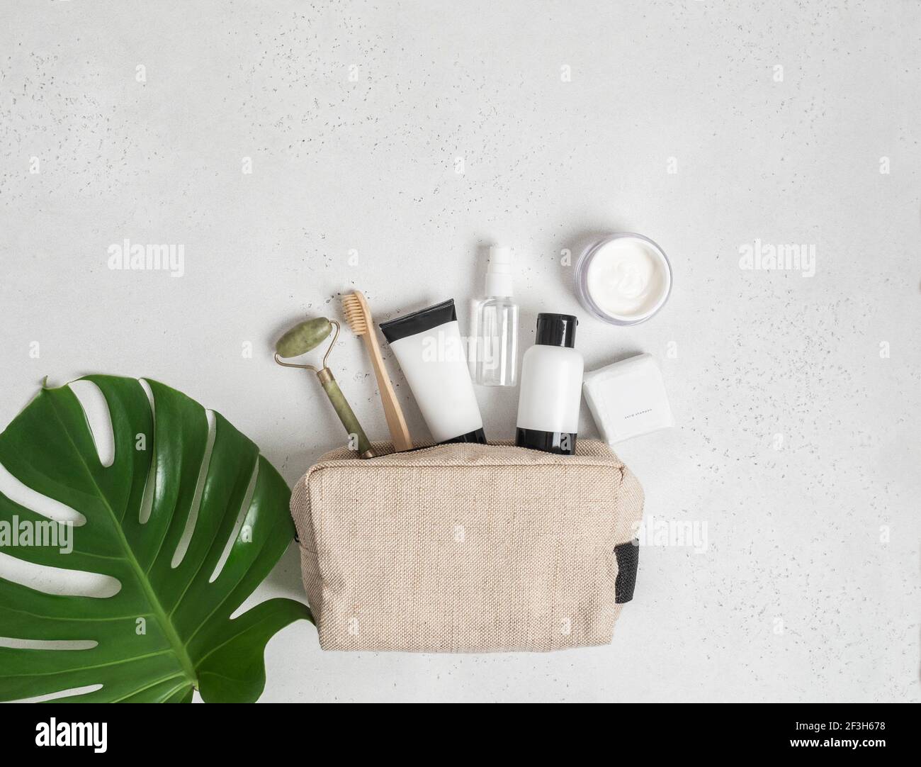 Travel cosmetic bag with the necessary means to care for women's skin. Cosmetics, massager with crystals, dry shampoo, cotton buds, toothbrushes in a Stock Photo
